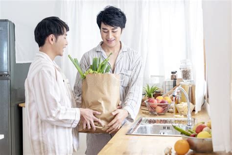 Asian Gay Couple Homosexual Cooking Together In The Kitchen Prepare Fresh Vegetable Make Organic