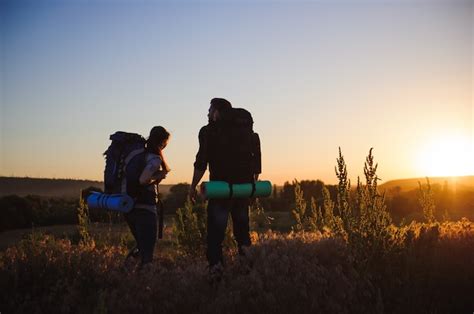 Premium Photo Silhouettes Of Two Hikers With Backpacks Walking At