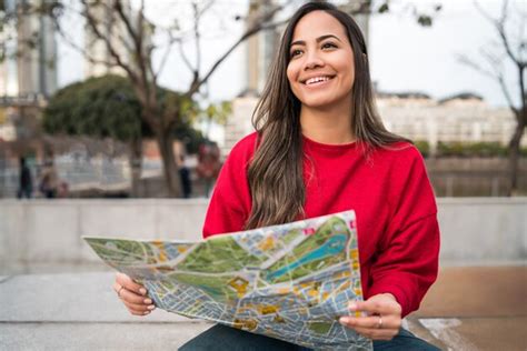 Retrato De Mujer Latina Joven Sosteniendo Un Mapa Y Buscando Direcciones Al Aire Libre En La