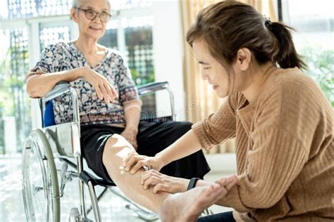 Mãe Asiática Sênior Em Cadeira De Rodas Recebendo Uma Massagem Na