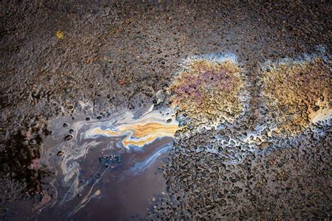 A Spot Of Oil Or Gasoline In A Puddle On The Asphalt Stock Photo