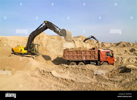 Excavator Loading Dumper Truck At Construction Site Stock Photo Alamy