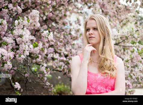 Blonde Woman In A Pink Dress Posing Within Flowers During The Summer Stock Photo Alamy