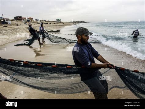 Gaza City, The Gaza Strip, Palestine. 12th Dec, 2019. Palestinian fishermen pull their nets at a ...