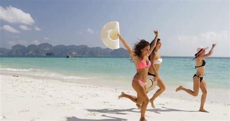 Muchachas En El Bikini Que Corre En La Playa Turistas Alegres Del