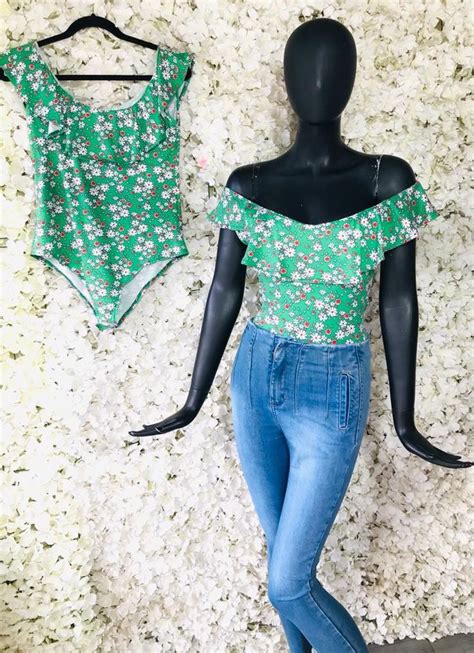 A Female Mannequin Is Standing Next To A Green Top And Blue Jean Pants