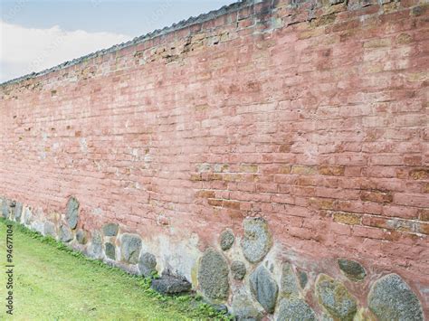 Red brick wall in garden Stock Photo | Adobe Stock