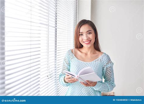 Livro De Leitura Da Jovem Mulher Perto Da Janela Foto De Stock Imagem