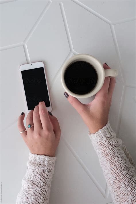 Woman On Her Phone While Drinking Coffee By Stocksy Contributor