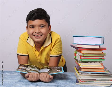 Indian School Boy Or Scholar Kid With Stack Of Books Stock Photo