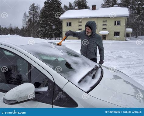 One Man Cleaning Snow From Car Windshield With Brush Removing Snow From