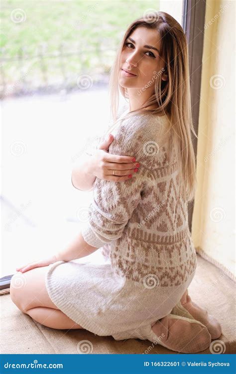 Girl Sitting On The Big Window In Cafe Single Women In Beige Knitted