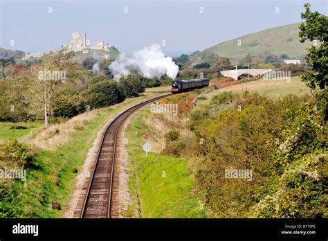 Steam Train Corfe Castle In Background On The Preserved Swanage Railway