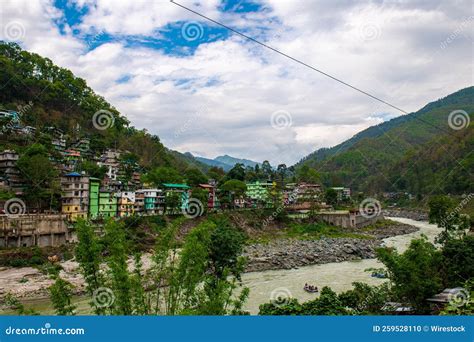 Colorful Residential Buildings Near River With Mountain Landscape In