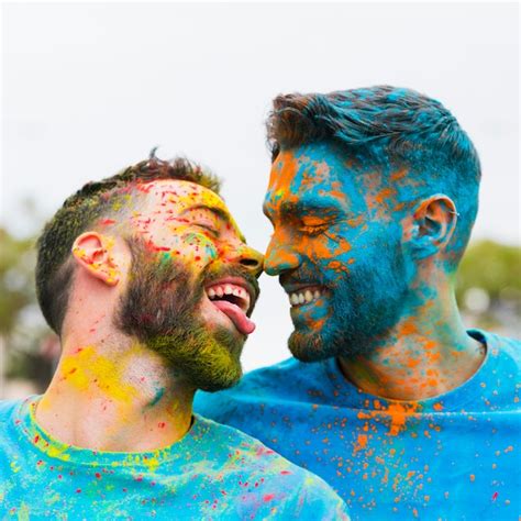 Gay divirtiéndose y besándose en festival holi Foto Gratis