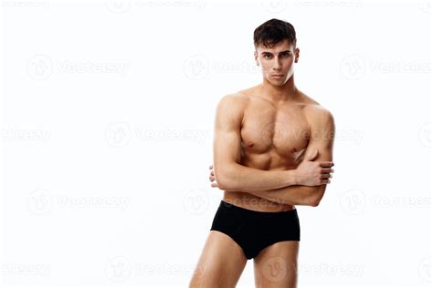 Nude Man In Black Panties Holds His Hands On His Chest On A Light Background Model