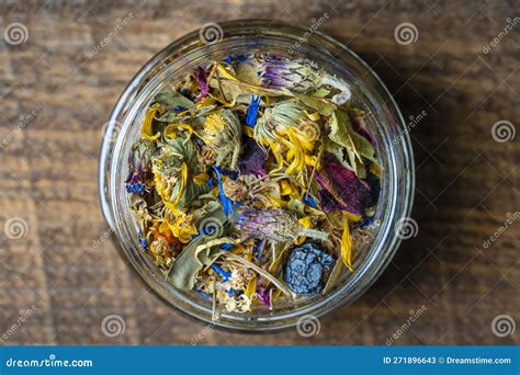 Dry Flower And Herbal Tea Leaves In A Glass Jar On Wooden Background