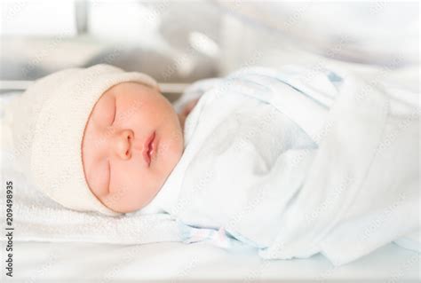 Cute newborn baby boy sleeping in hospital bed. Stock Photo | Adobe Stock