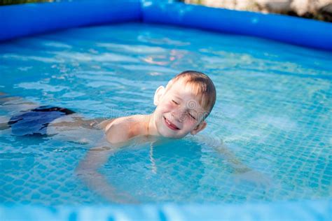 Blonde Junge In Blauen Schwimmkoffer Schwimmt In Einem Aufblasbaren Pool Stockfoto Bild Von