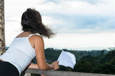 Premium Photo Shot Of The Back Of A Girl Brunette Looking Towards The Horizon While Waving Her