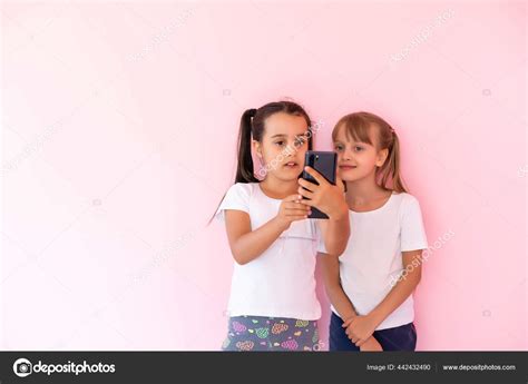 Deux Petites Filles Jouant Avec Des Smartphones Sur Un Fond Rose Image