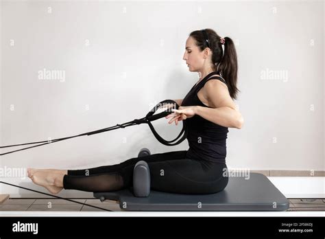 A woman doing pilates exercises on a reformed bed Stock Photo - Alamy