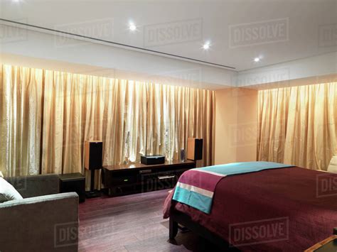 Bedroom with gold curtains and hardwood floor - Stock Photo - Dissolve