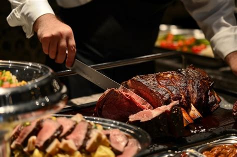 Premium Photo Waiter Slicing A Prime Rib At A Carving Station During