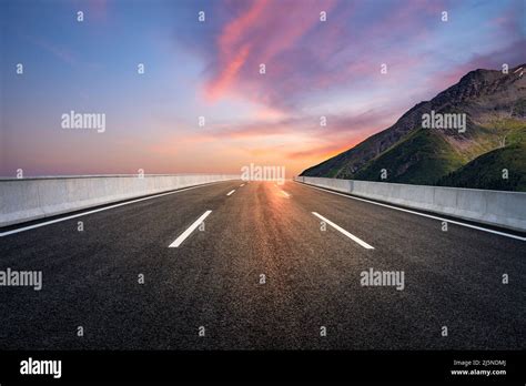 Asphalt Road And Mountain With Beautiful Sky Clouds At Sunrise Stock