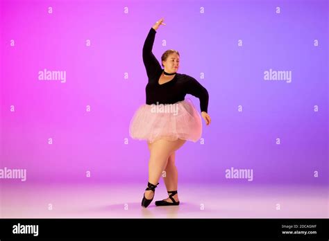 Lightful Beautiful Caucasian Plus Size Model Practicing Ballet Dance On Gradient Purple Pink