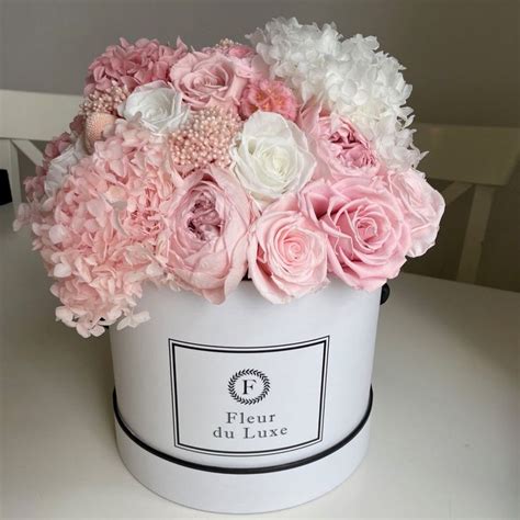 A White Bucket With Pink And White Flowers In It