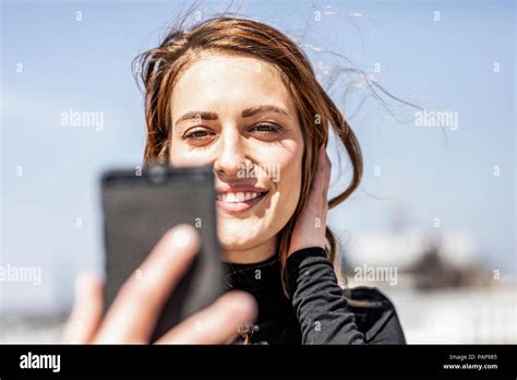 Portrait Of Smiling Woman Taking Selfie With Smartphone Stock Photo Alamy