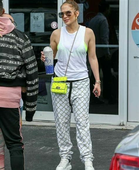 A Woman In White Top And Patterned Pants Holding A Yellow Purse While