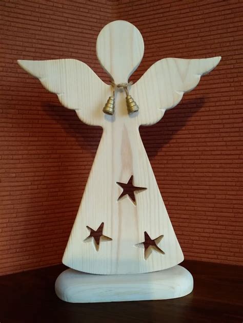 A Wooden Angel With Three Stars On It