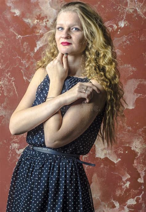 Jong Meisje Met Blonde Krullend Haar In Een Lange Kleding Met Stippen Met Teddybeer Stock Foto