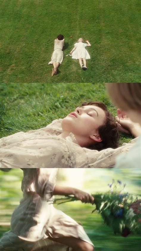 Two Women Laying In The Grass With One Woman Holding Flowers And