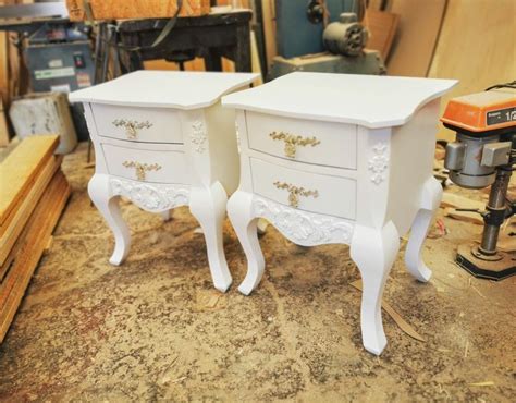 Two White Nightstands Sitting On Top Of A Wooden Floor