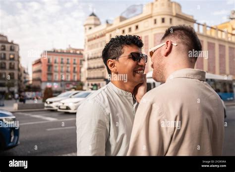 A Multiethnic Gay Couple Shares A Loving Smile Amidst An Urban Setting Highlighting A Moment Of