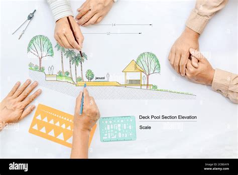 Landscape Architect Changing Drawing At Meeting With Client Stock Photo