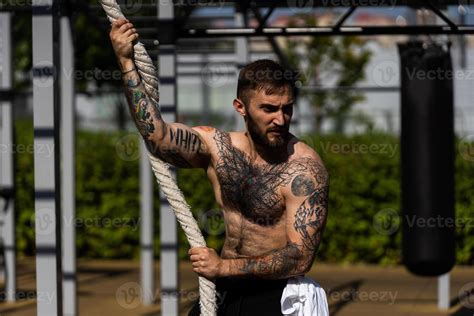 Muscular Bodybuilder Handsome Man With Naked Torso Trains Triceps In A Crossover Cable Exercise