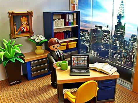 A Doll Sitting At A Desk In Front Of A Laptop Computer With A View Of