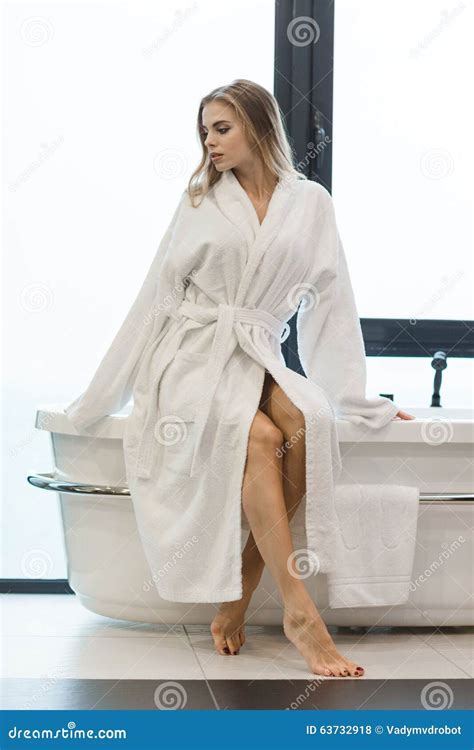 Beautiful Sensual Barefooted Female In White Bathrobe Sitting On