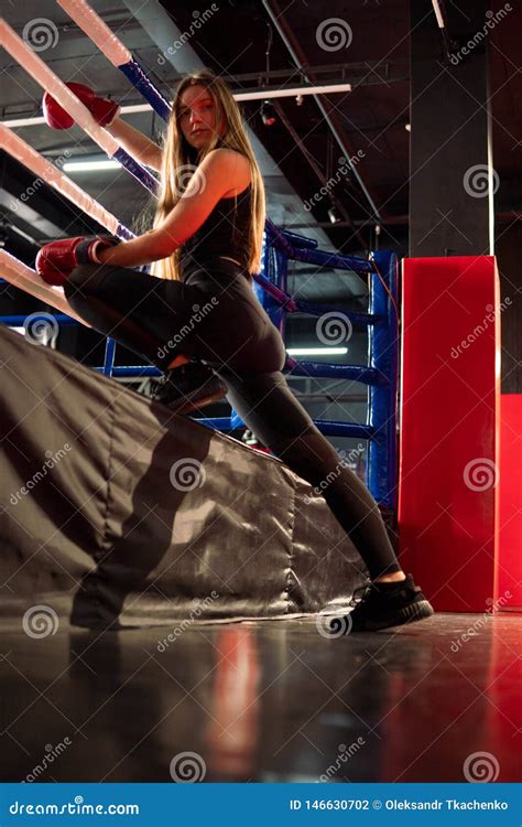 Blonde Caucasian Fighter Girl In Red Boxing Gloves Is Posing On Fight Club Boxing Ring Stock