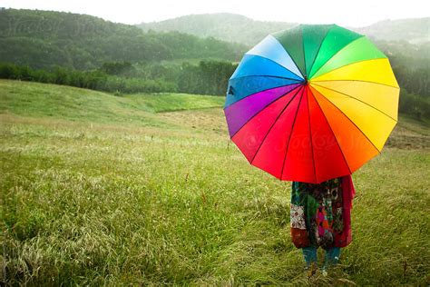 Woman With Colorful Umbrella Enjoying Rain In The Meadow By Stocksy