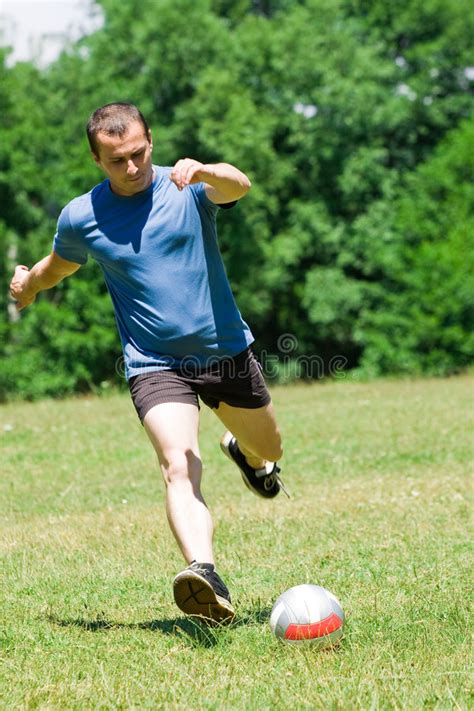 Jugador De Fútbol Que Golpea La Bola Con El Pie Imagen de archivo