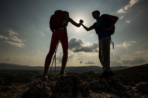 Premium Photo | Young couple hiking on the mountain at sunset