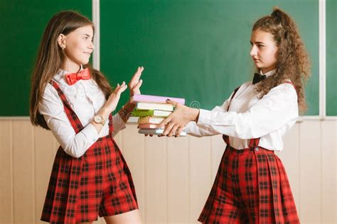 Zwei Brunette Schulm Dchen In Den Schulroten Uniformen Stehen In Einem Klassenzimmer