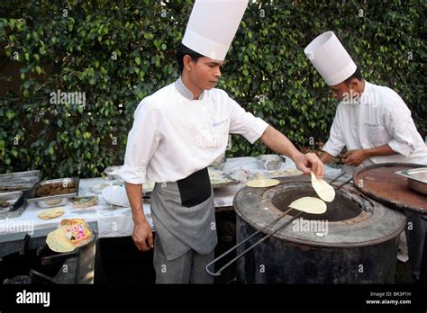 Two Cooks Prepare Chapati Bread In A Traditional Tandoori Oven During A