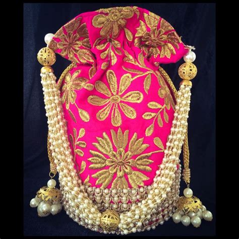 A Pink And Gold Purse With Tassels On The Bottom Beads Around It