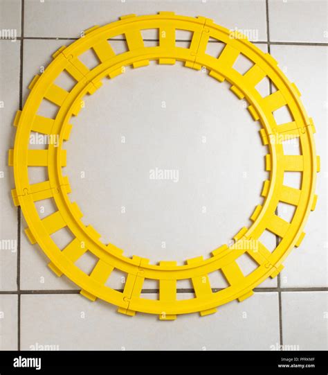 Plastic yellow toy train tracks laid in a circle Stock Photo - Alamy